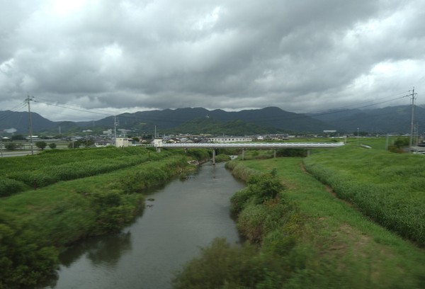 Taget från Relay Kamome, 24 minuter ut från Takeo-onsen och 36 minuter innan ankomsten till Hakata i Fukuoka. Översvämningsrisken och beredskapen präglar landskapet.