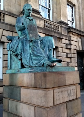 Alexander Stoddart’s statue of David Hume (1711–1776) at the top of Edinburgh’s Royal Mile. Students wishing for luck rub his toes, keeping them shiny, while a bagpiper lurks just off screen to the right.
