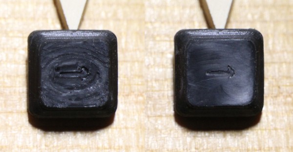One arrow key, as produced by `dmote-keycap` v0.5.1 and prepped with a soldering iron, before and after sanding the top for a few seconds on these jigs, all the way up to P1200 grit.