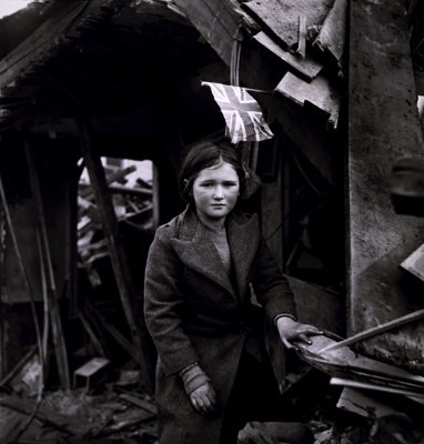 Flicka med brittisk flagga framför ruin, foto från V2-bombningen av Battersea 27 januari 1945, av Toni Frissell.