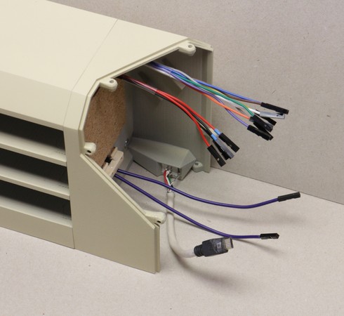 A stage in the assembly of a Concertina v0.7.0. Here, the right-hand bookend subassembly has been prepared as shown here, then attached to the central housing with screws at the assortment-drawer seam, and then the bundled wires originating in the left-hand side (shown here) have been routed through the left-hand bookend (also attached to the central housing as shown here)), and through the loft of the central housing, to poke into the right-hand bookend.