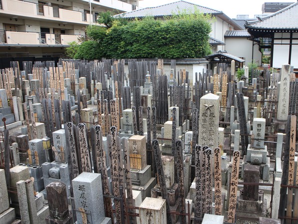 Mångra andra gravfält ligger på bergssluttningarna runt om staden, men för att ta den här bilden behövde jag bara sträcka mig över en mur i ett tätbebyggt område i Kyoto. Byggnaden i bakgrunden är ett buddhistiskt tempel, Daizō-ji (大藏寺).