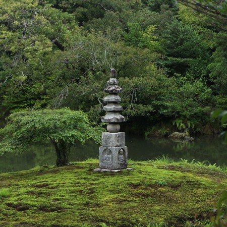 Buddhor sitter i basen på den här stenpagoden, Hakuja-cho, på en egen ö i den mindre dammen Anmintaku (安民沢) vid Kinkakuji.